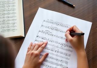 Hands pointing at sheet music during a music theory lesson